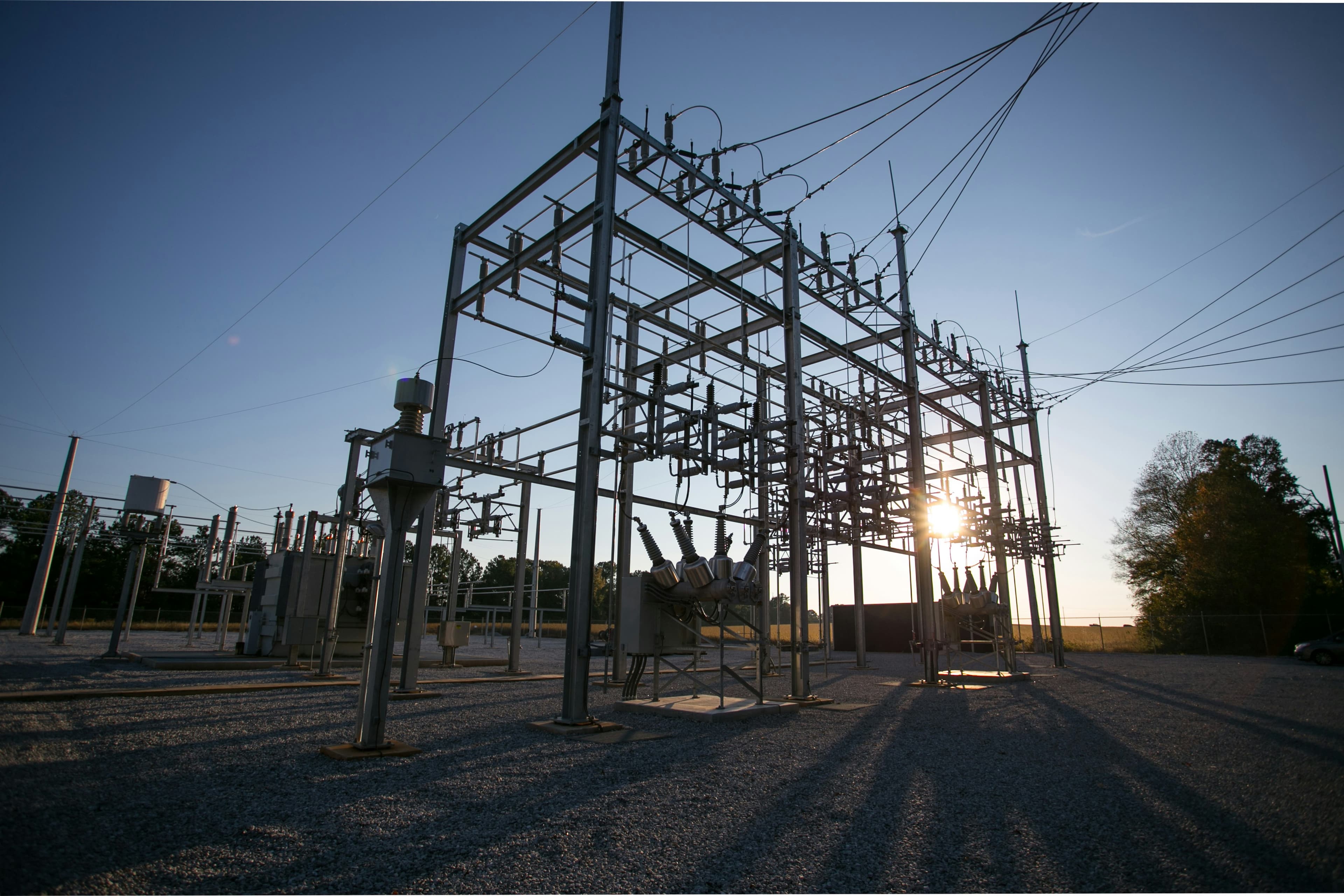Electrical substation at sunset with the sun behind its steel structure